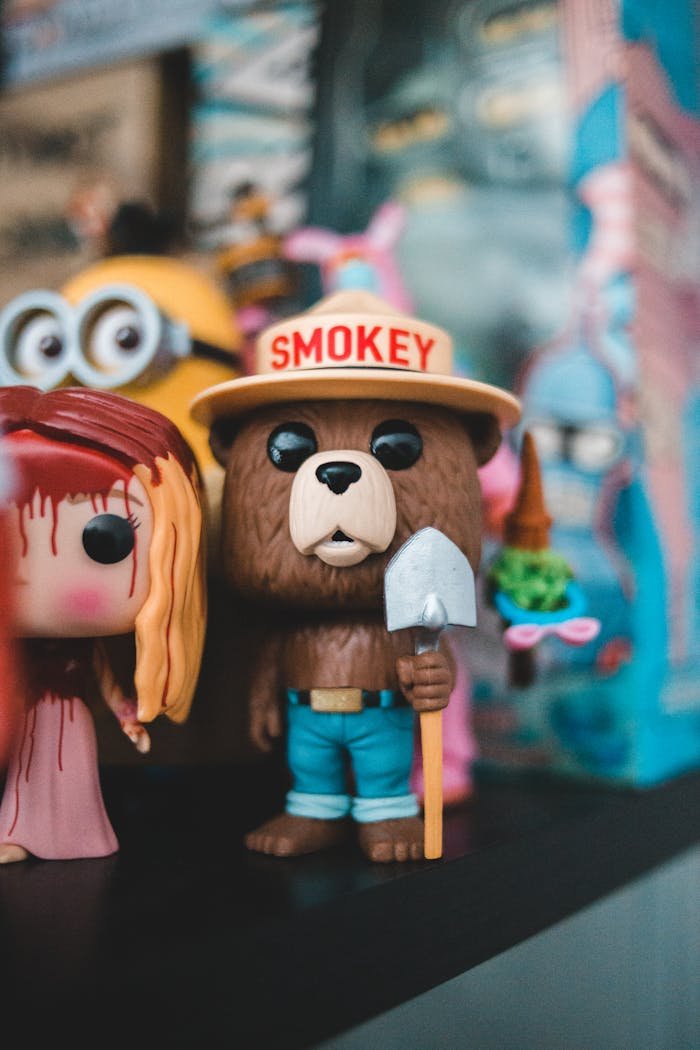 Vibrant collection of figurines featuring a bear and doll on a shelf.